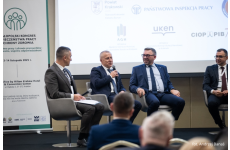 Czterech mężczyzn na scenie Kongresu w tym OIP z Warszawy wypowiadający się do mikrofonu