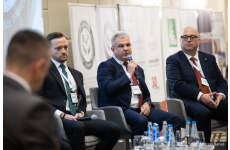 Trzech okręgowych inspektorów siedzących podczas panelu eksperckiego w tym wypowiadający się do mikrofonu OIP z Krakowa