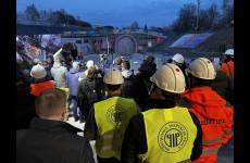 Stojąca grupa osób obserwująca wylot tunelu kolejowego