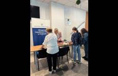 Stoisko poradnicze OIP w Krakowie przy którym osoby pobierają publikacje o tematyce prawnej